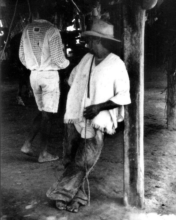 Llanero con sombrero junto a un poste de madera